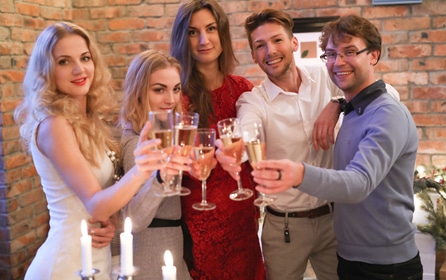 A diverse group of individuals joyfully raising champagne flutes in celebration